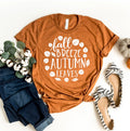 Rust orange t-shirt with white fall quote, paired with rolled dark jeans, striped flats, and cotton stems