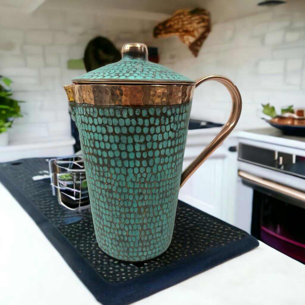 Artist-designed turquoise and copper pitcher with textured pattern on modern kitchen counter