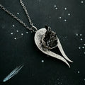 handcrafted silver pendant necklace with textured heart and rough black stone on starry background