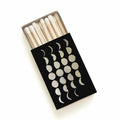 Black matchbox with metallic moon phases design, cosmic boutique gift item, white matches