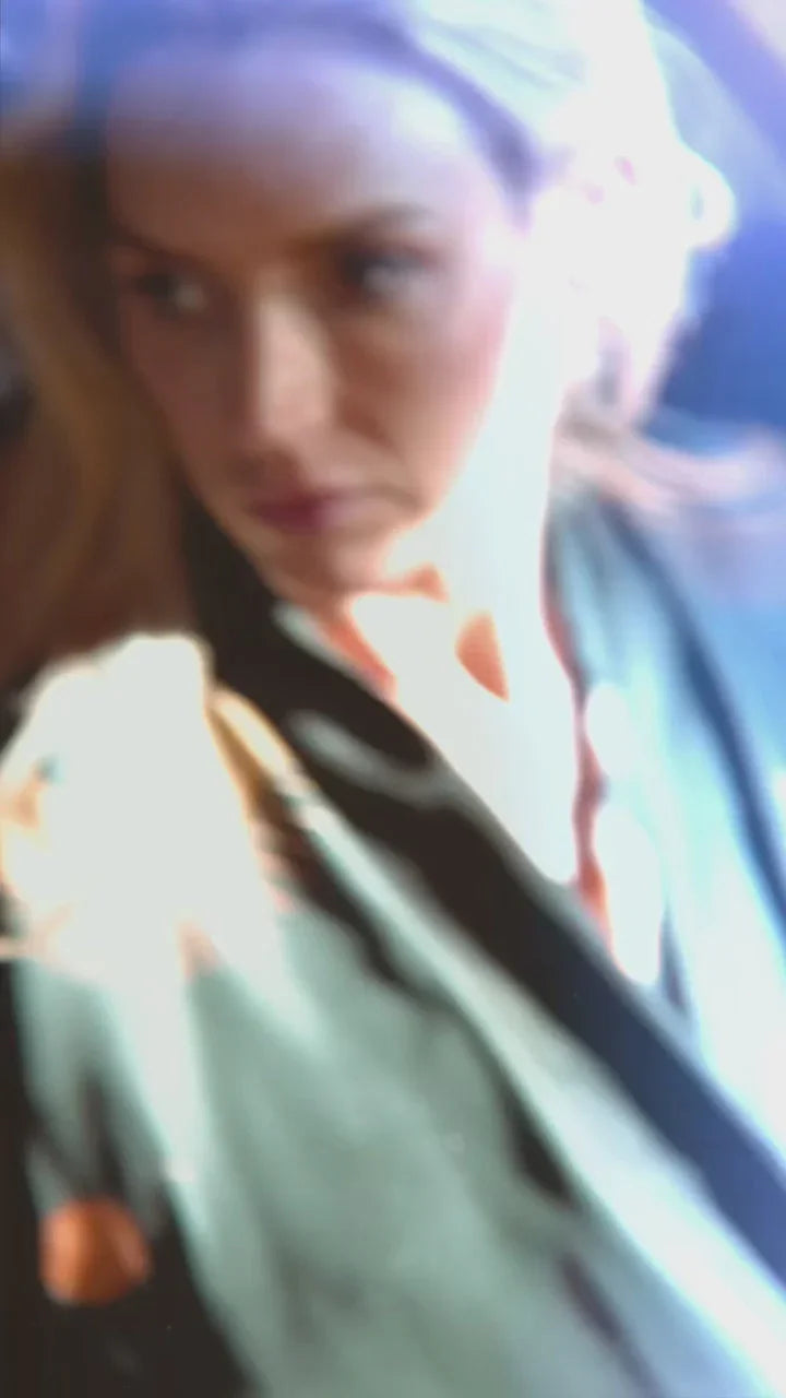 Blurry close-up of a woman wearing a patterned garment with soft lighting