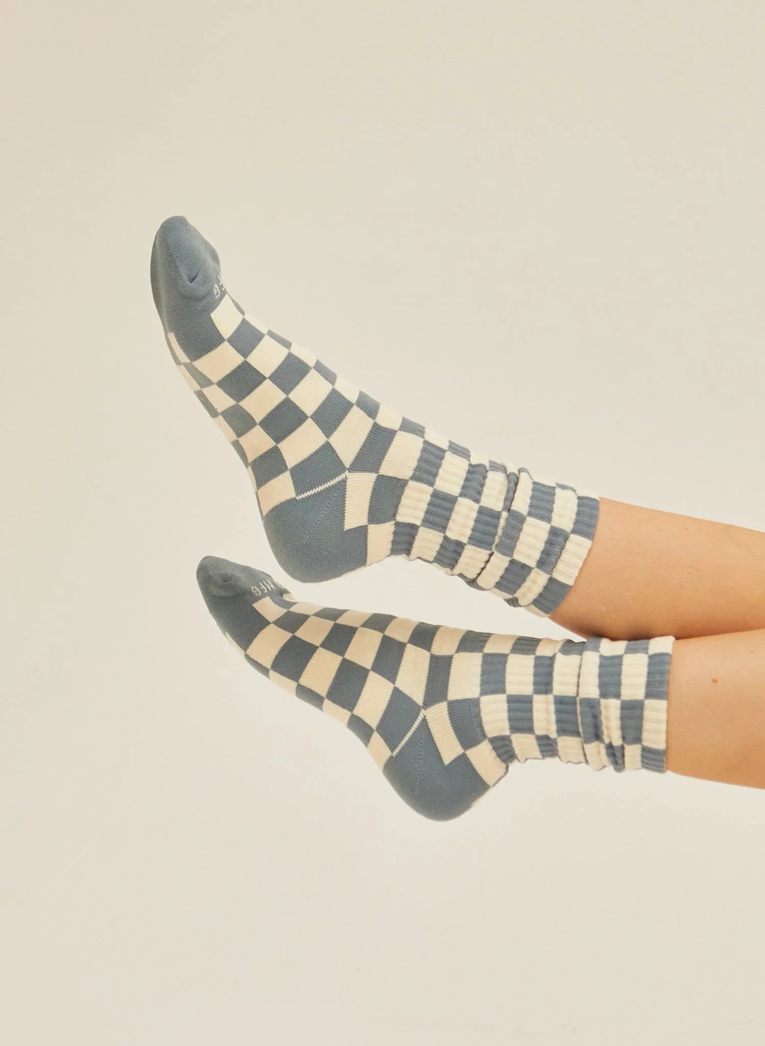 Blue and cream checkerboard crew socks on feet, sustainable fashion at Qu!rk Boutique