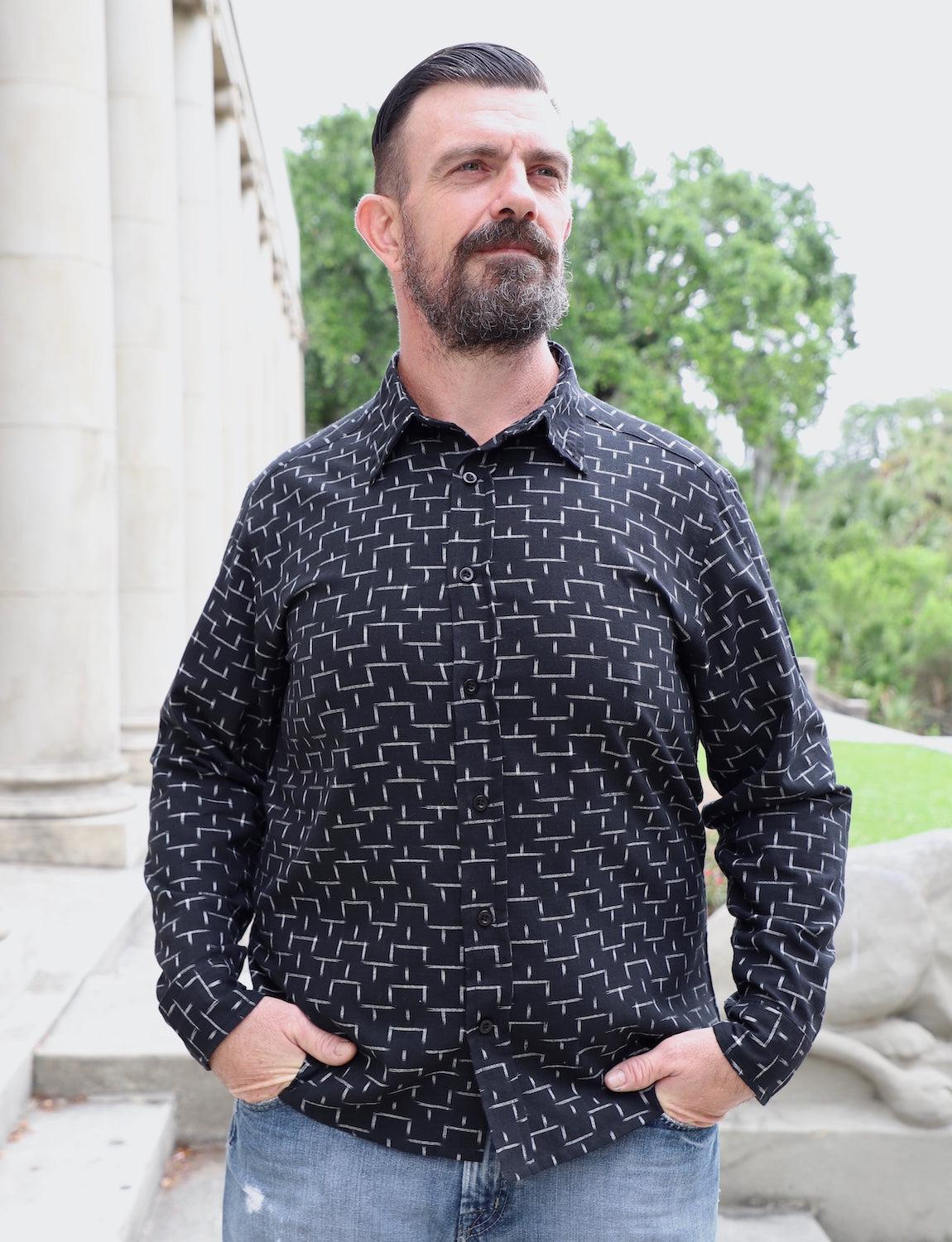 Man modeling black geometric print button-down shirt outdoors at Qu!rk Boutique