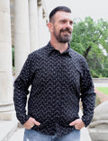 Man wearing a black geometric button-down shirt from Qu!rk Boutique outdoors