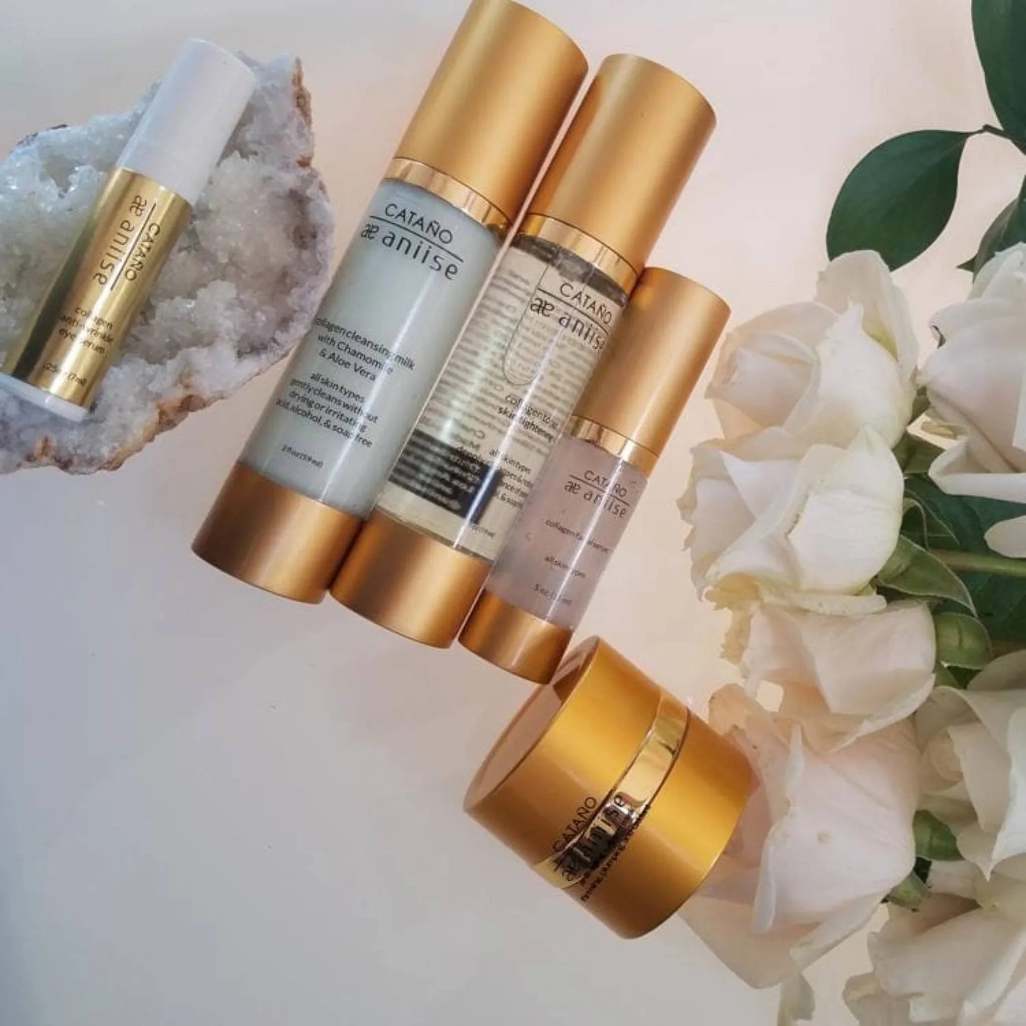 Catano æAnilise collagen anti-aging skincare set with gold containers, white flowers, and crystal, featured at Qu!rk Boutique & Gift Shop