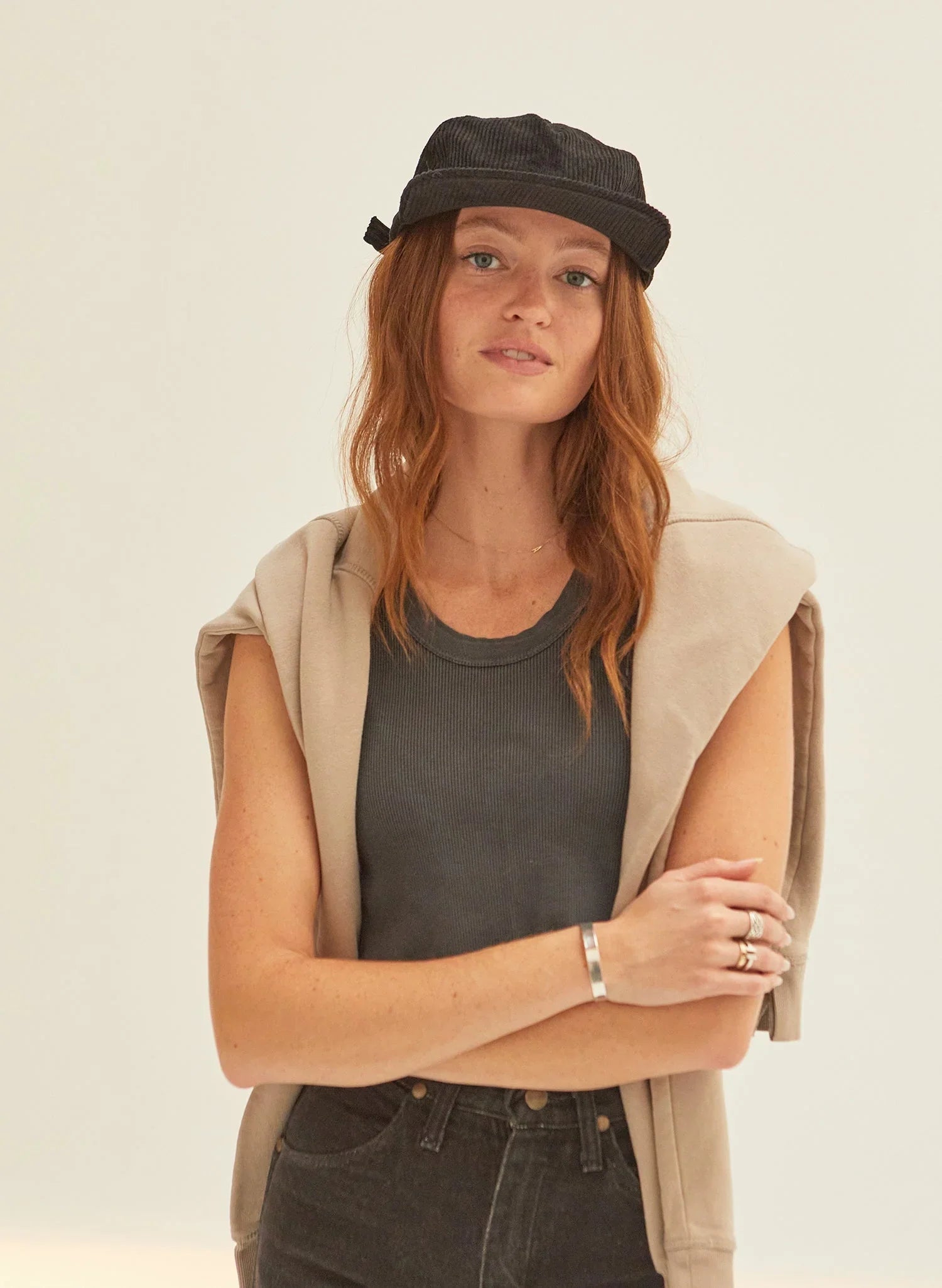 Woman in a black corduroy cap and casual outfit from Qu!rk Boutique, minimalist background