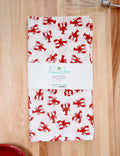 Red crawfish print cotton tea towel on wood table, eco-friendly kitchen gift from Qu!rk Boutique
