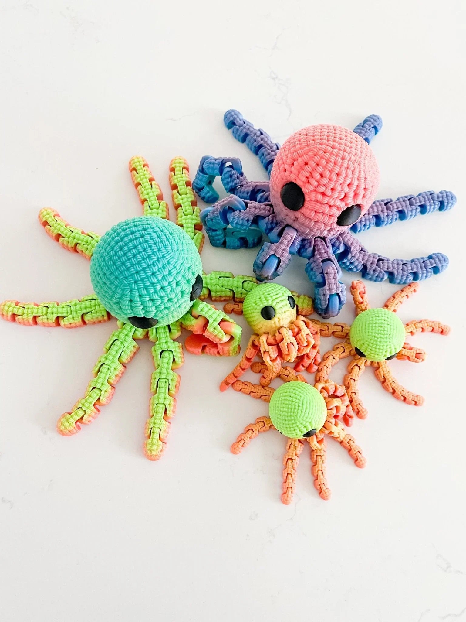 Colorful crocheted octopus plush toys displayed on a white background at Qu!rk Boutique.