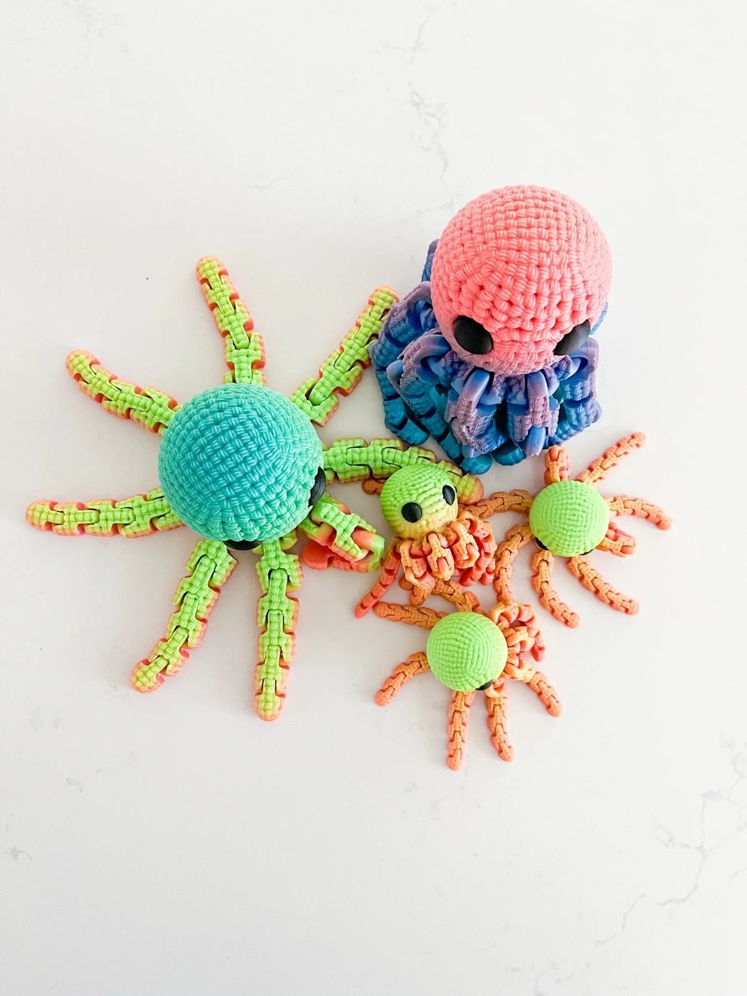 Handmade crocheted octopus toys in vibrant colors on a white surface, Qu!rk Boutique gift.