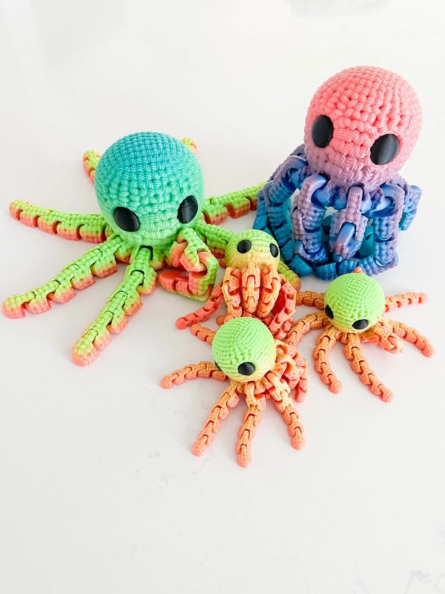 Colorful crocheted octopus toys in neon green and pink on a white background, Qu!rk Boutique
