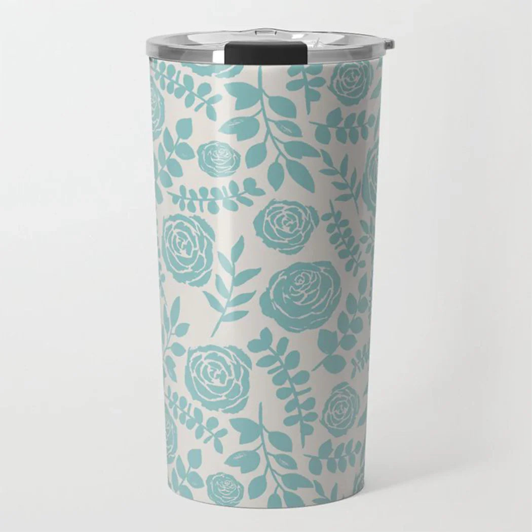 Stainless steel travel tumbler with teal floral and leaf pattern on white background