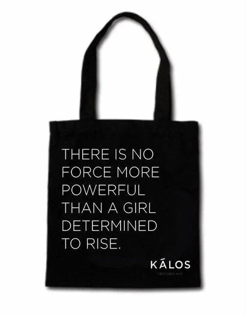 Black tote bag with white inspirational text 'There is no force more powerful than a girl determined to rise' and KALOS logo