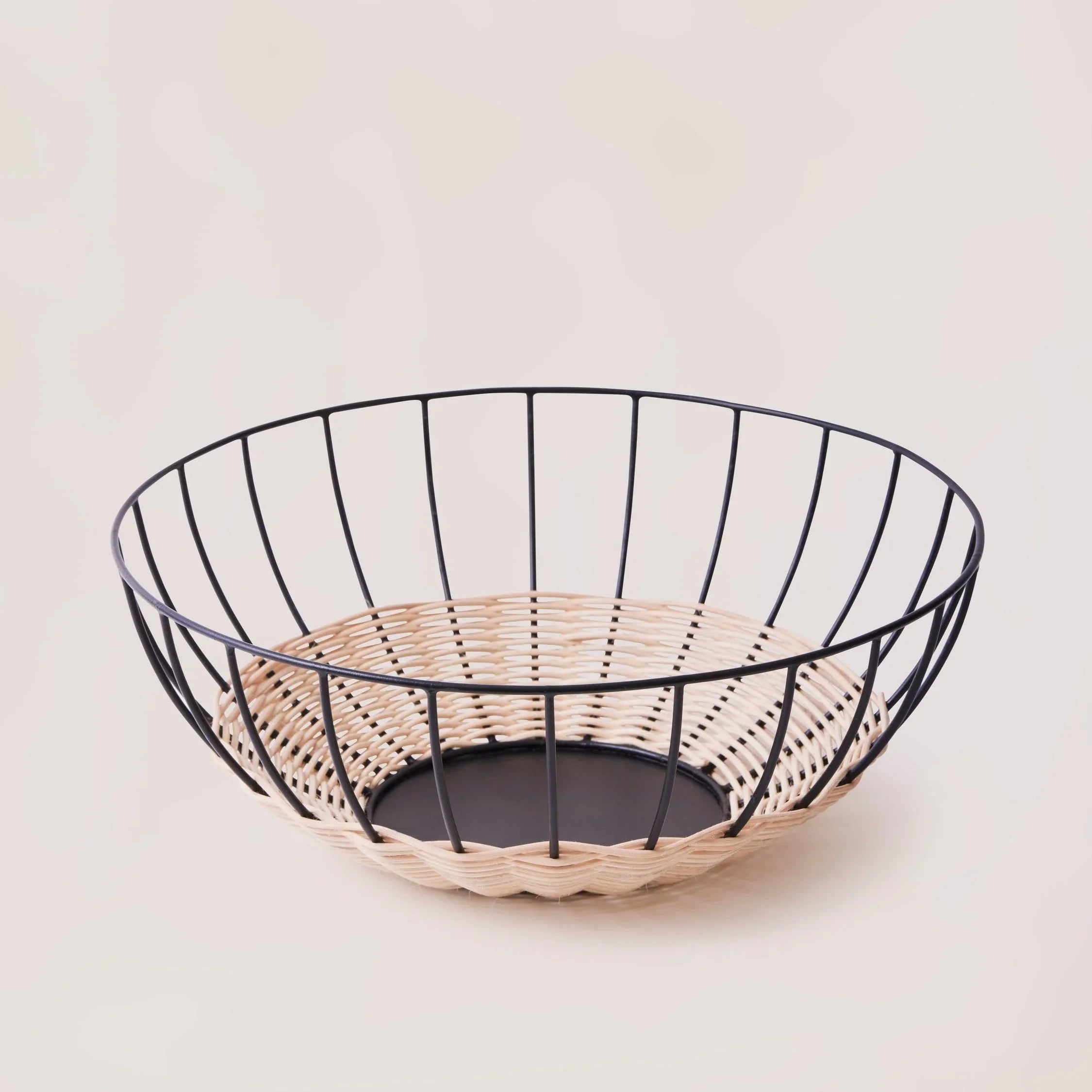 Modern woven wire and rattan fruit bowl on neutral background at Qu!rk Boutique