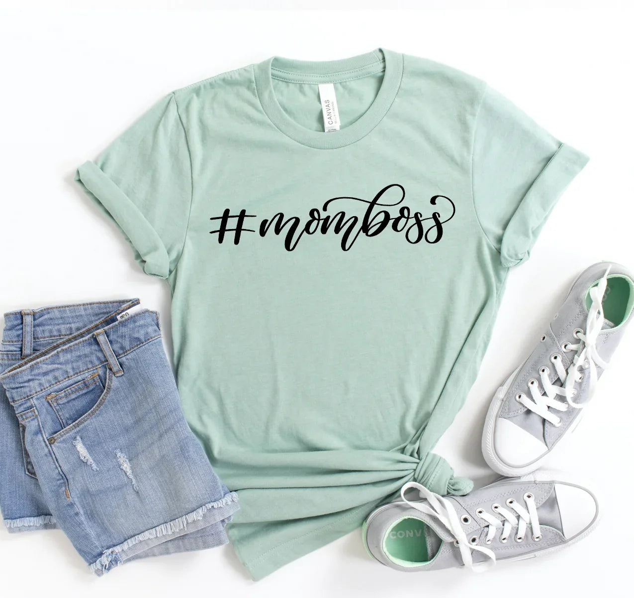 Light green t-shirt with #momboss print, paired with denim shorts and gray sneakers