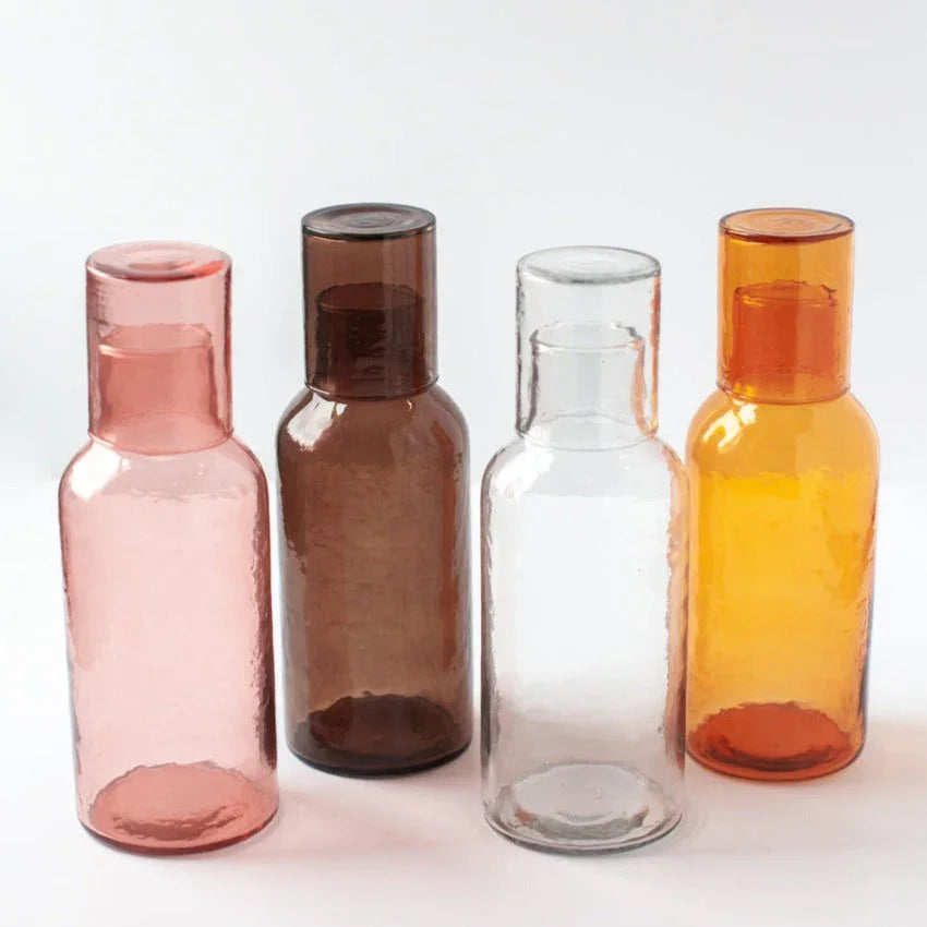 Set of four recycled glass carafes in pink, brown, clear, and amber at Qu!rk Boutique