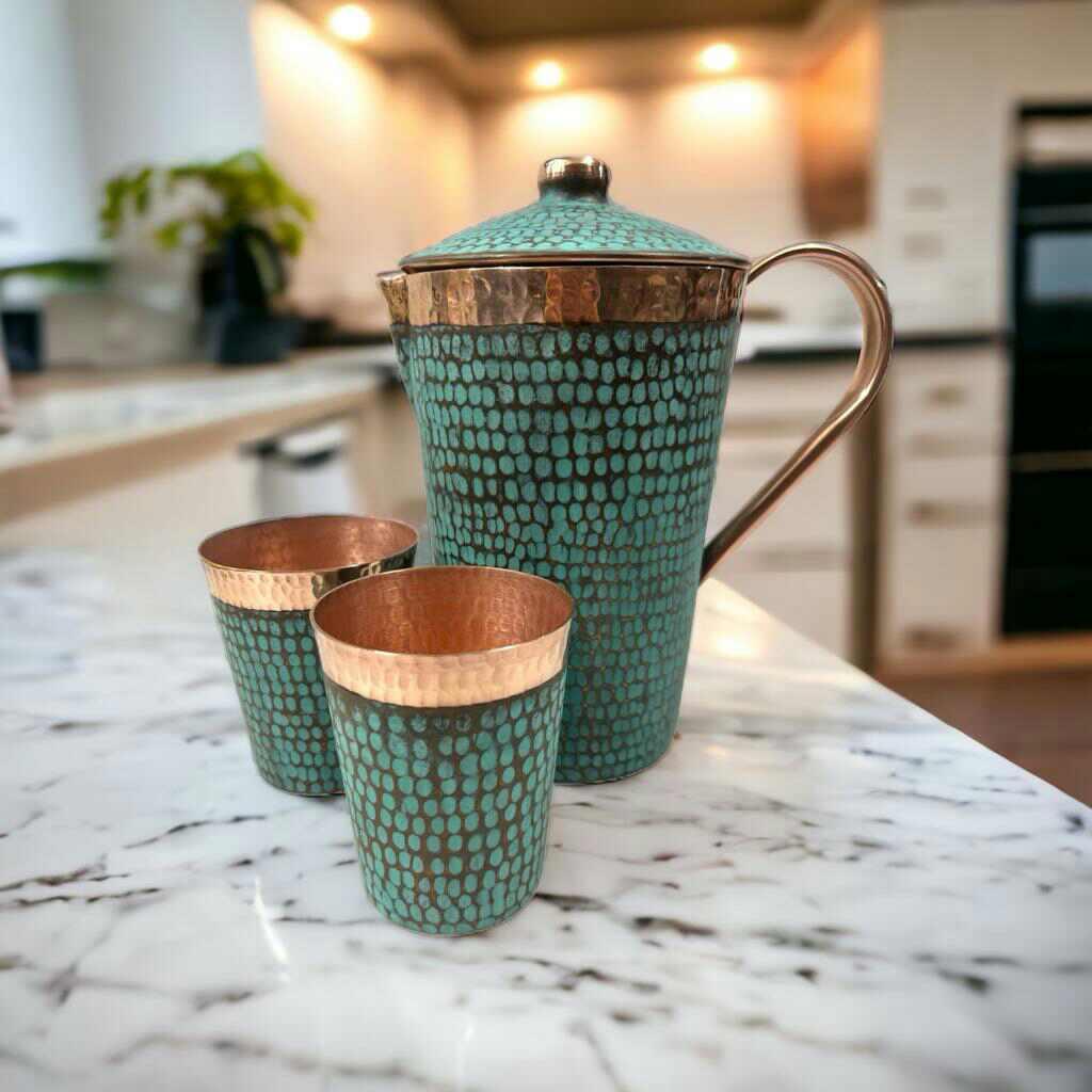 Handcrafted copper pitcher and tumblers with teal pattern on marble countertop, Qu!rk Boutique style