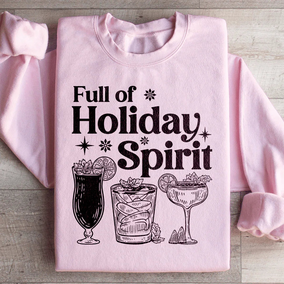 Light pink sweatshirt with black print reading Full of Holiday Spirit and illustrations of festive cocktail glasses