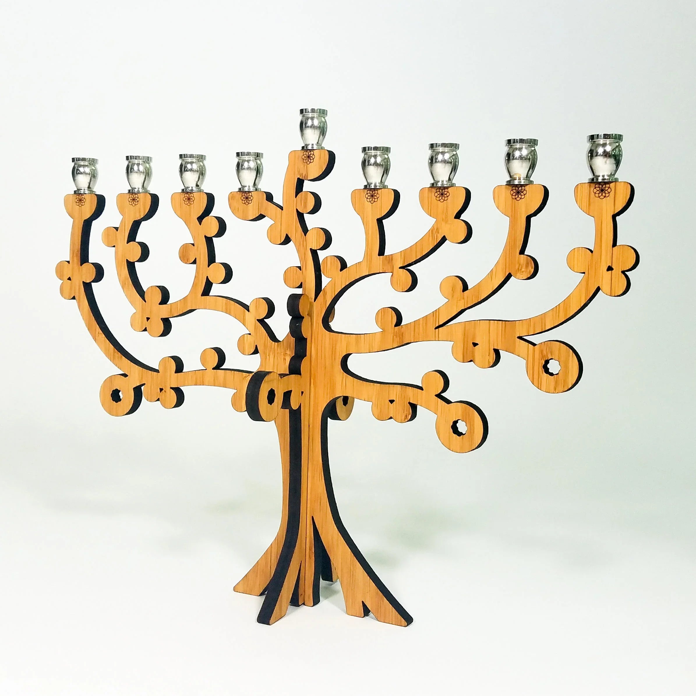 Wooden tree-shaped menorah with silver candle holders on a white background