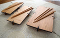 Bamboo sushi serving sets with engraved boards and wooden chopsticks on textured placemat