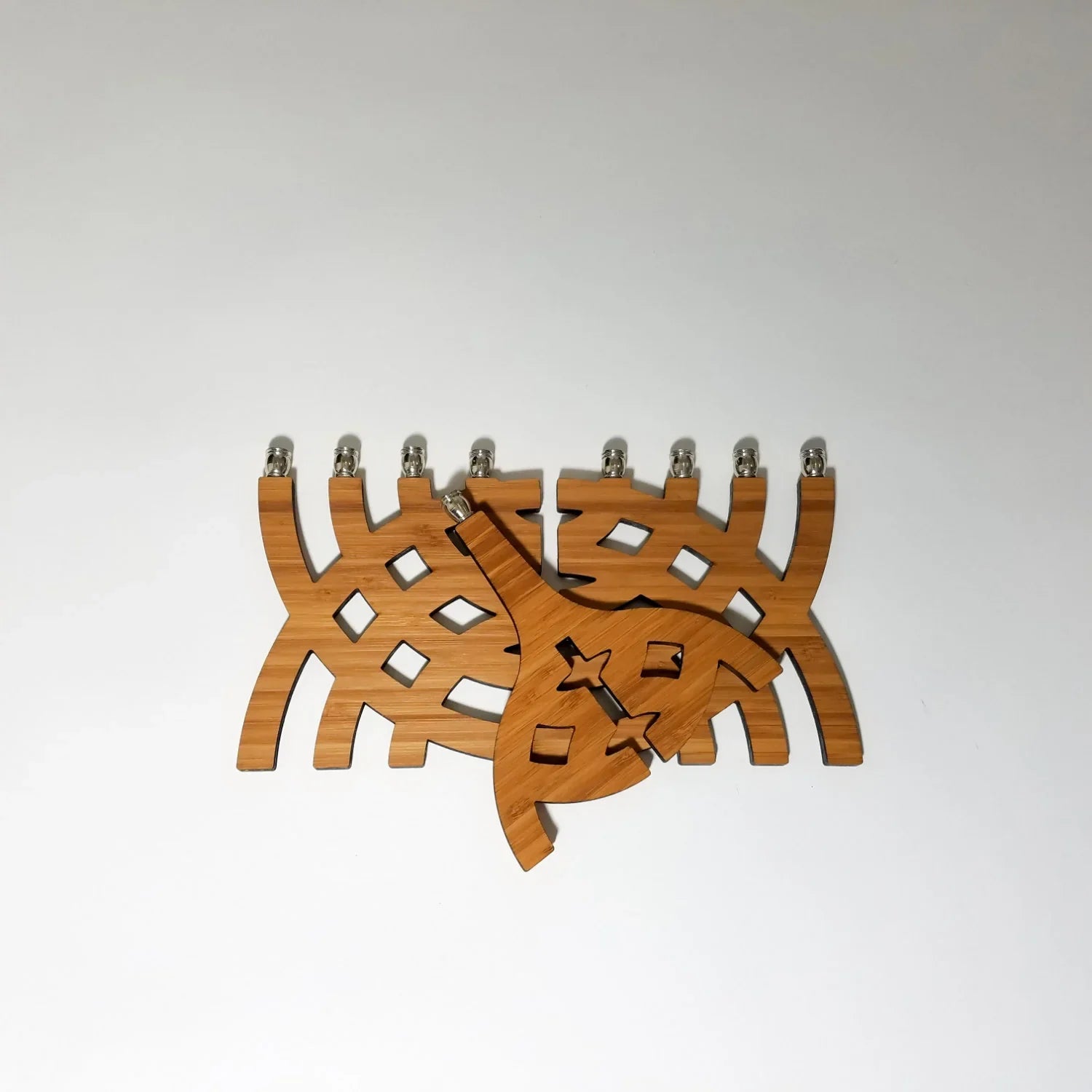 Wooden Menorah with intersecting arcs design and silver candleholders on white background