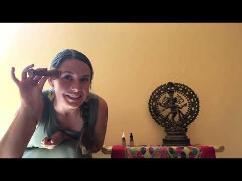 Woman applying makeup with brush beside ornate statue and colorful cloth at Qu!rk Boutique