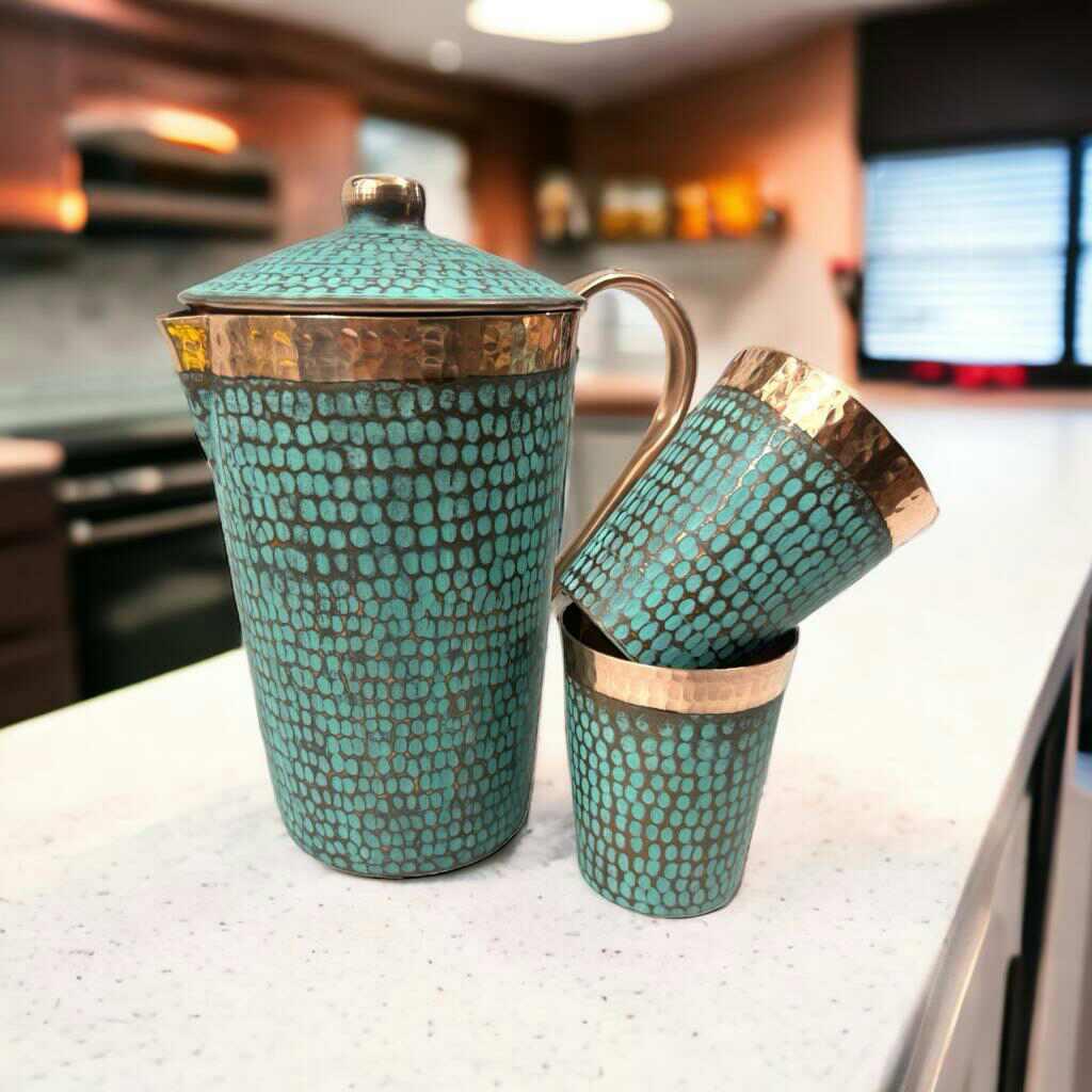 Turquoise and gold hammered pitcher set with cups on a kitchen counter, artist-designed giftware