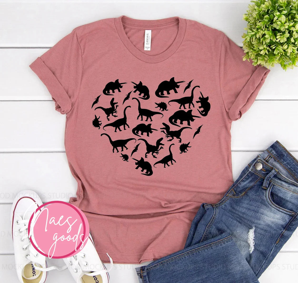 Dusty pink t-shirt with black dinosaur silhouettes forming a heart, styled with jeans and white sneakers