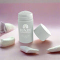 BUNZIE powder stick with open cap on pink surface, surrounded by cotton pads, at Qu!rk Boutique