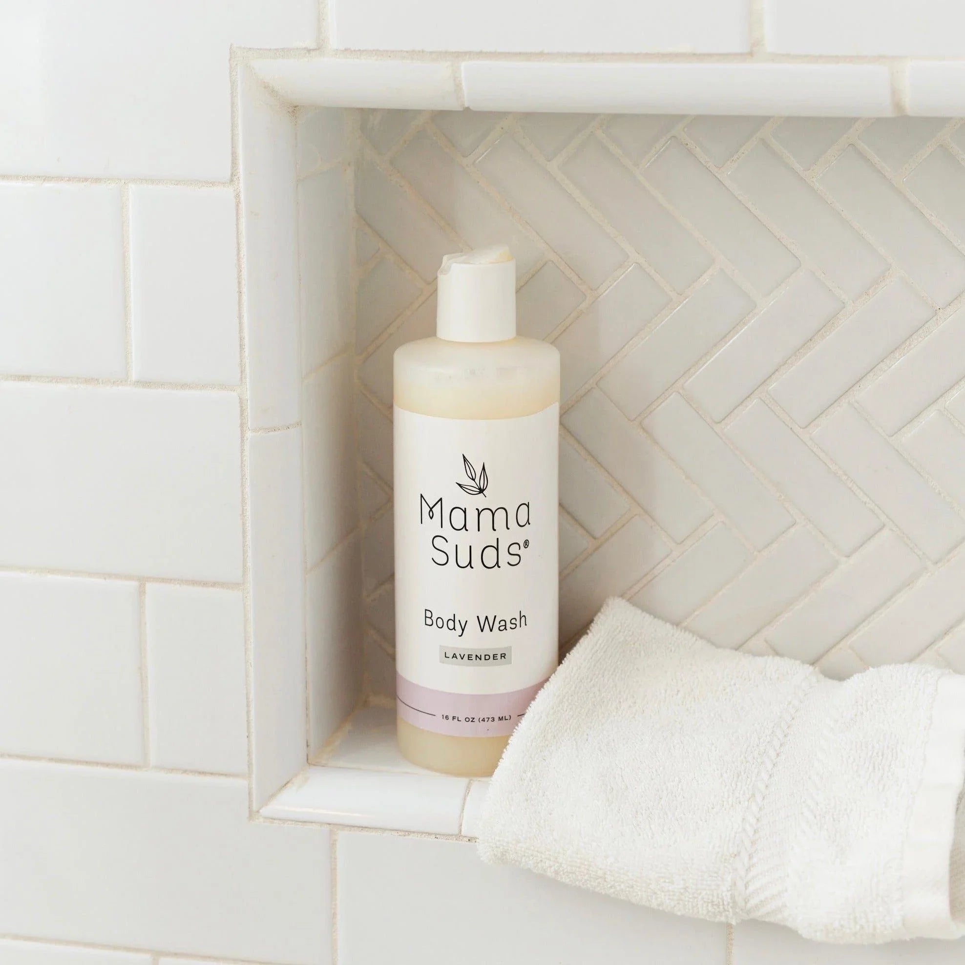 Mama Suds lavender body wash bottle in tiled shower niche with white towel, Qu!rk Boutique.
