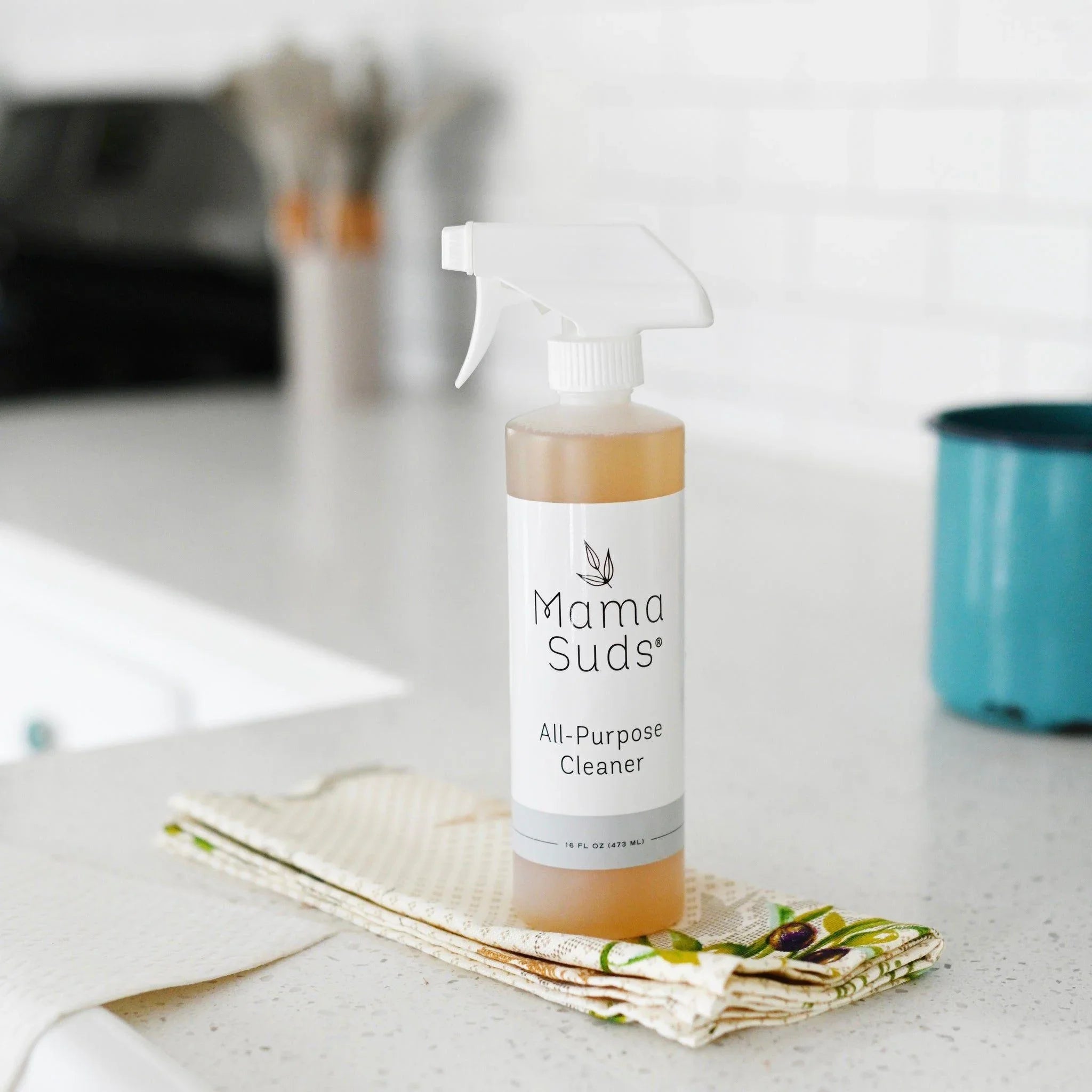 Mama Suds all-purpose cleaner on kitchen counter with cleaning cloths, eco-friendly gift
