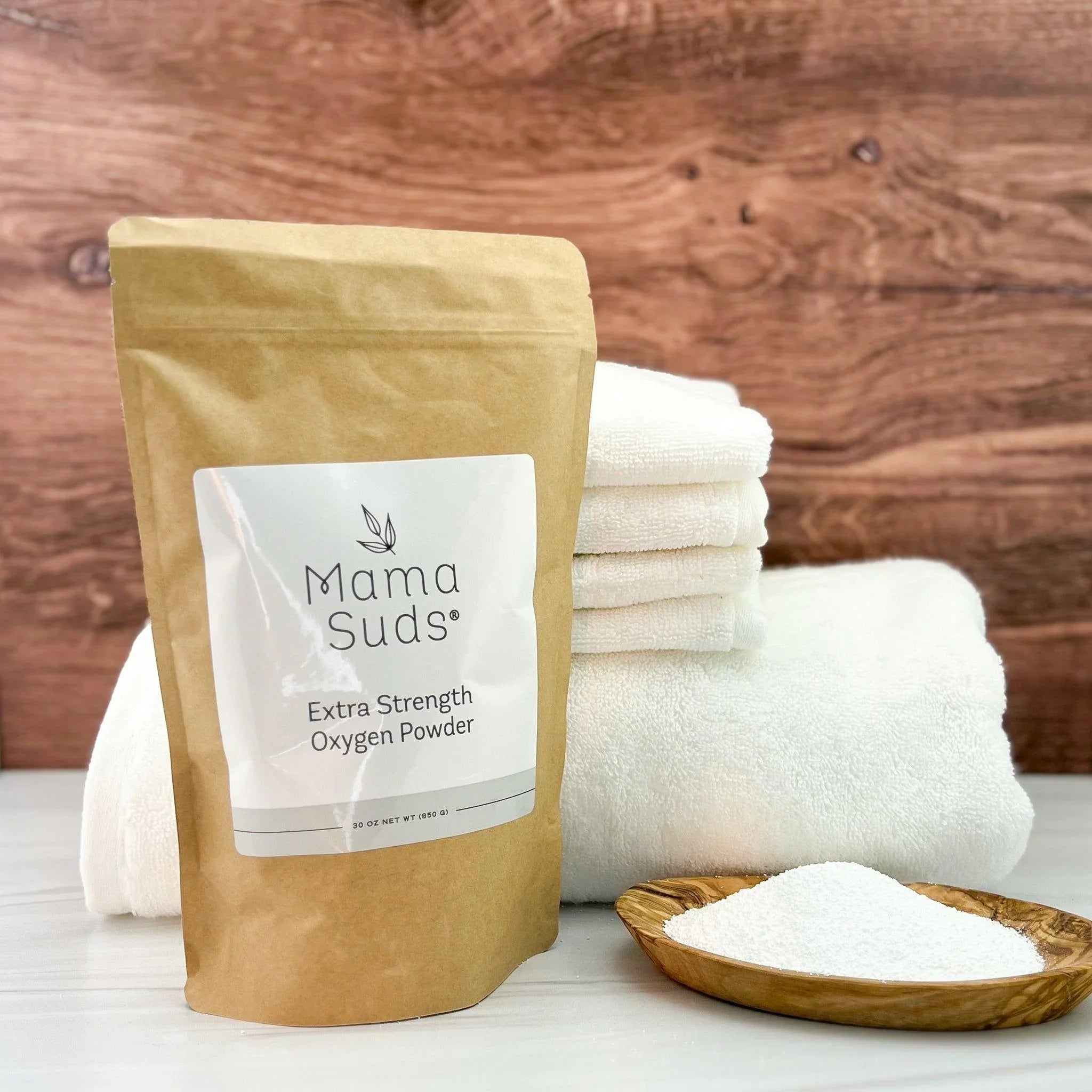 Mama Suds Extra Strength Oxygen Powder with stacked white towels and wooden bowl of powder