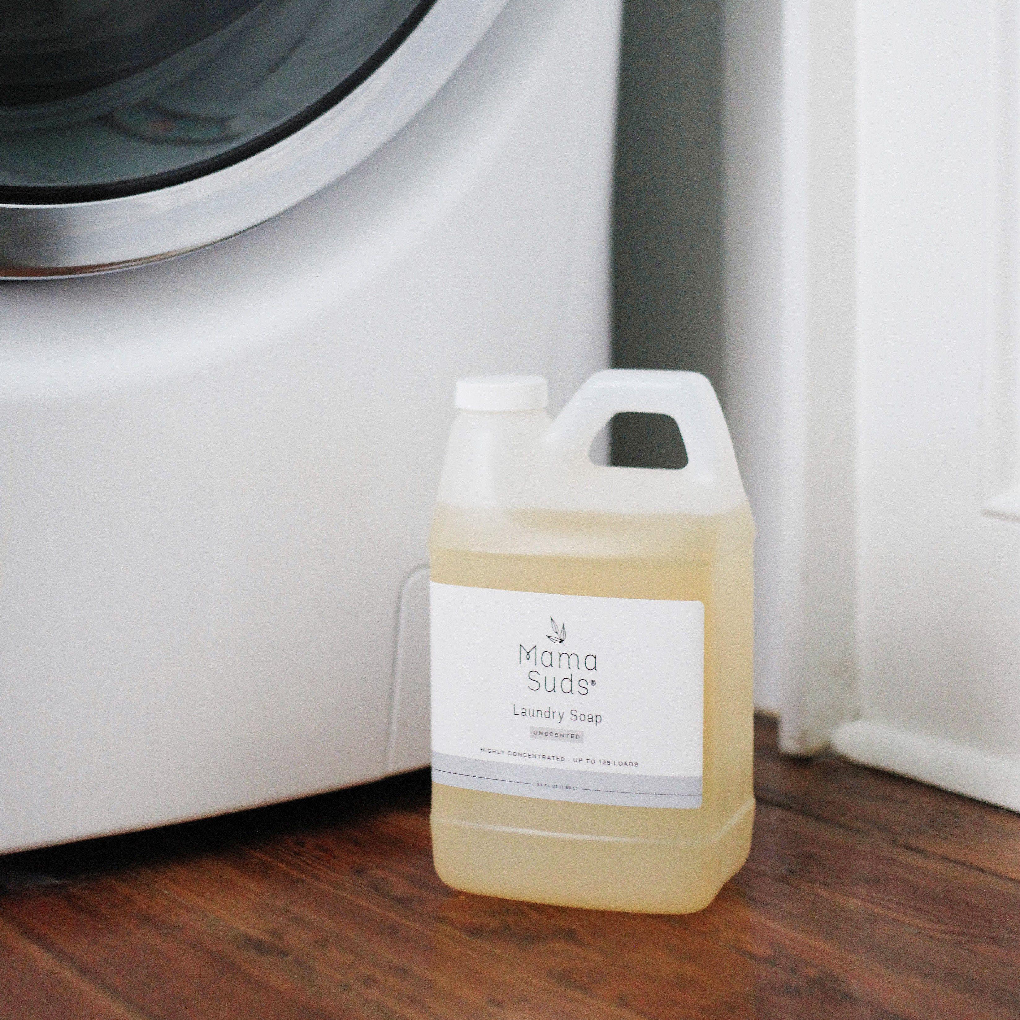 Mama Suds unscented laundry soap jug beside washing machine on wooden floor