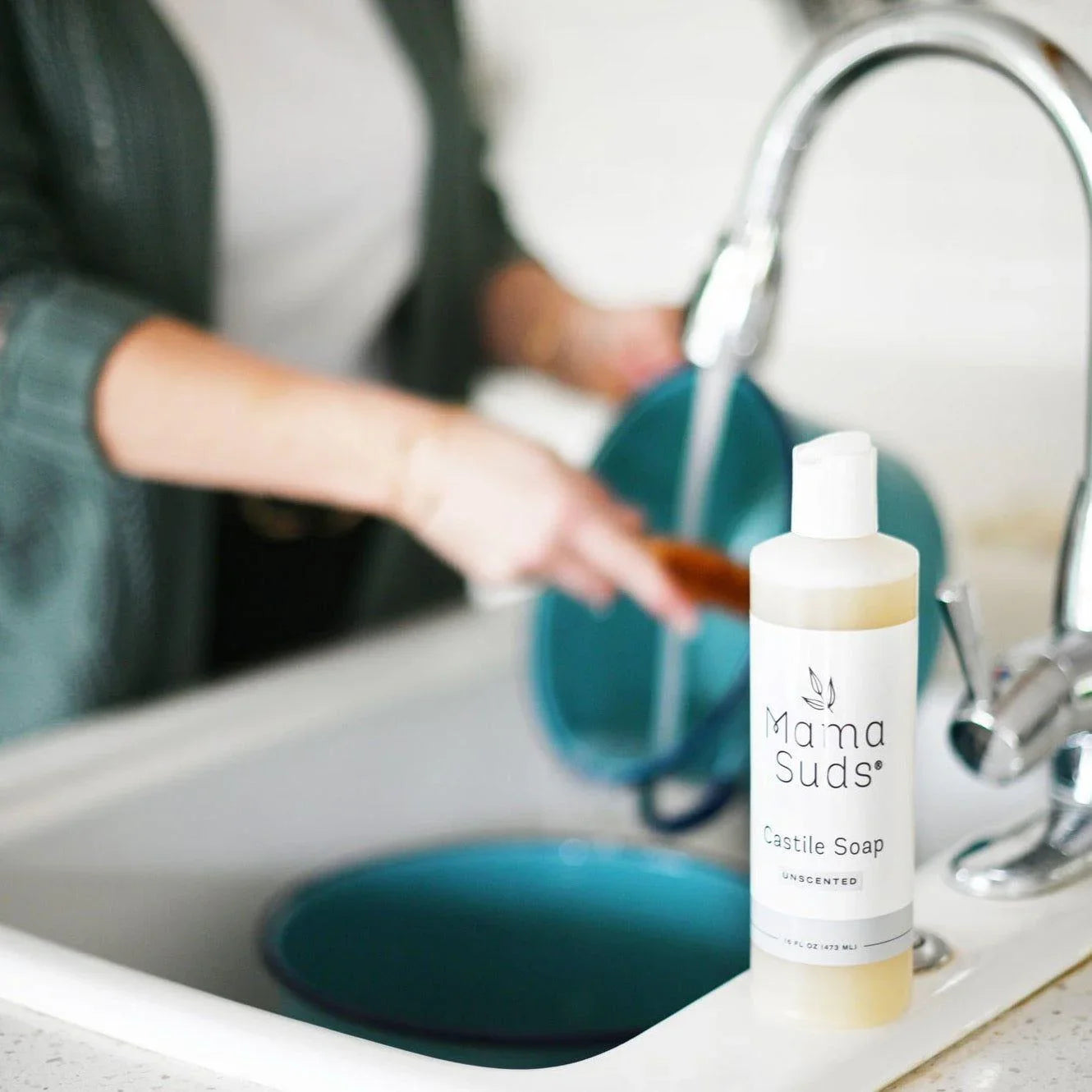 Woman washing dishes with Mama Suds Castile Soap in a modern kitchen at Qu!rk Boutique