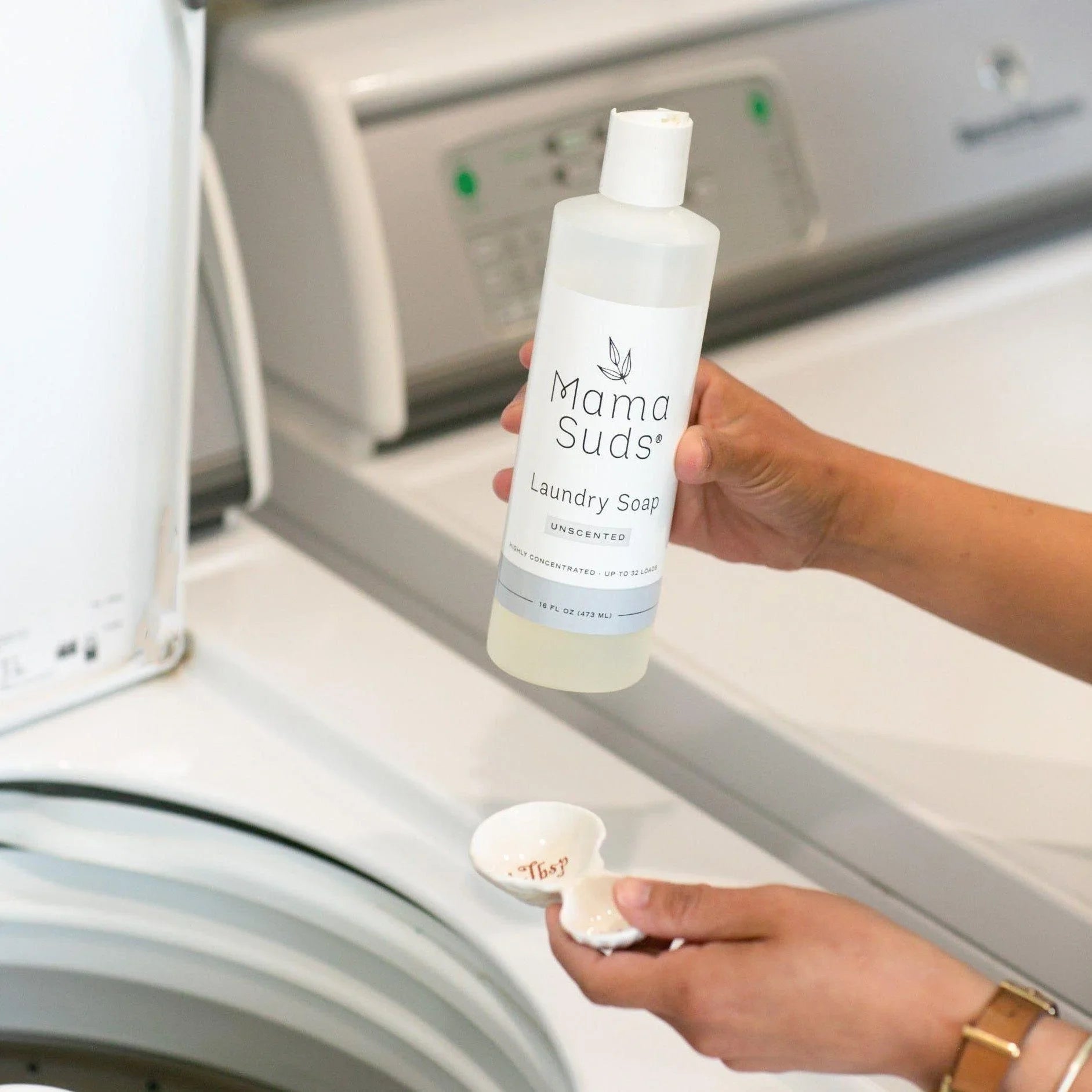 Pouring Mama Suds unscented laundry soap into a washing machine at Qu!rk Boutique