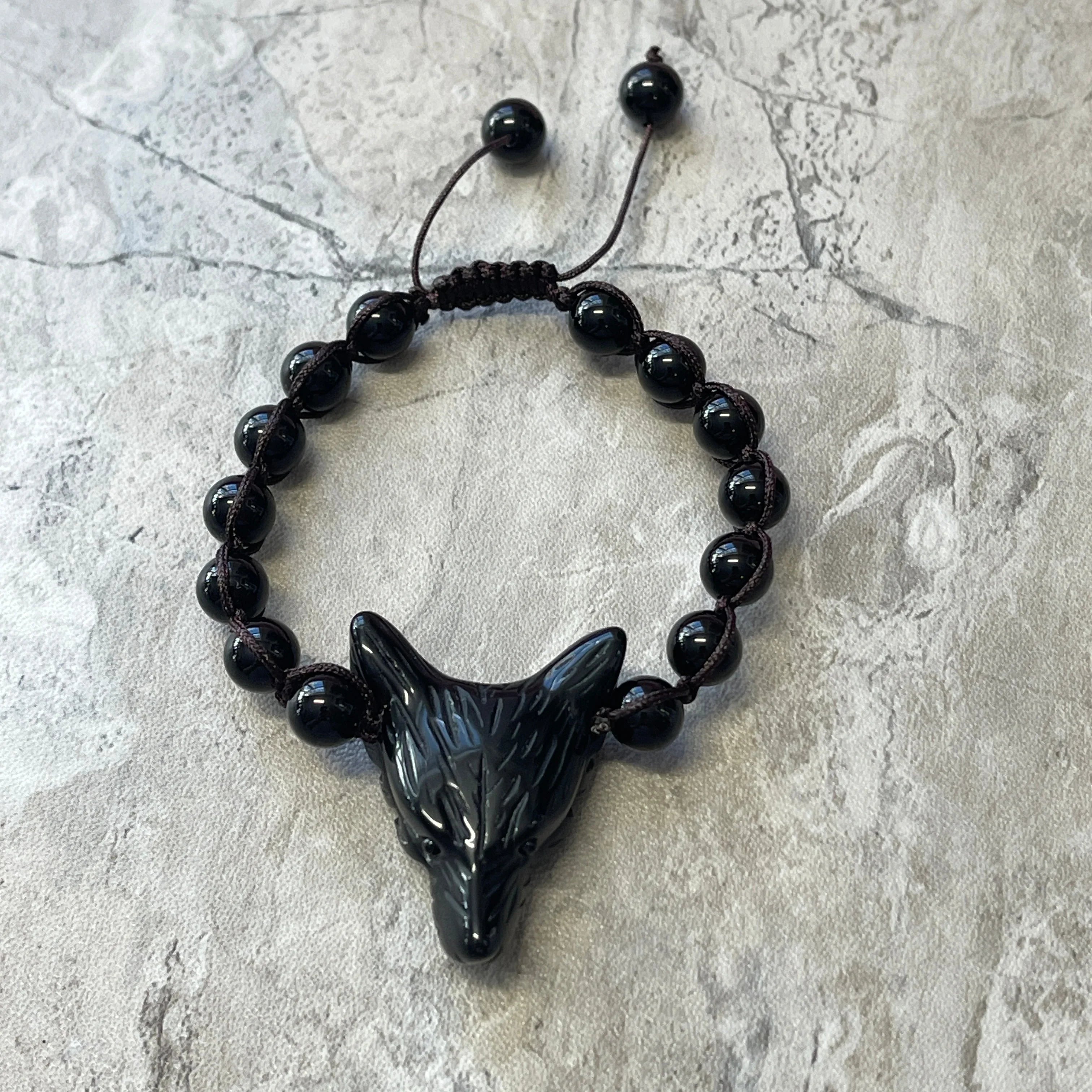 Black wolf head beaded bracelet on gray stone background, Qu!rk Boutique artist-designed jewelry