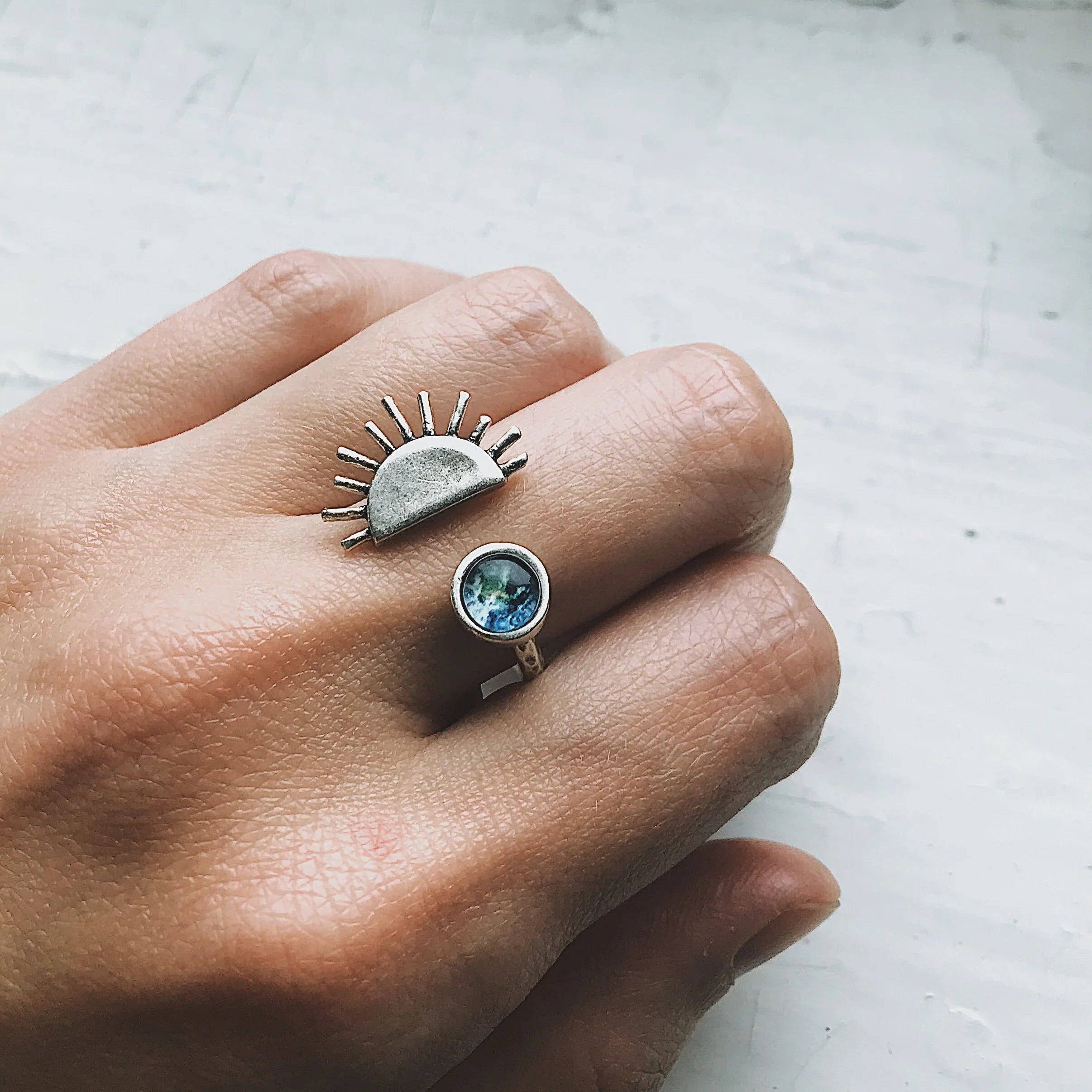 Hand wearing a sun and galaxy-themed statement ring from Qu!rk Boutique, cosmic jewelry