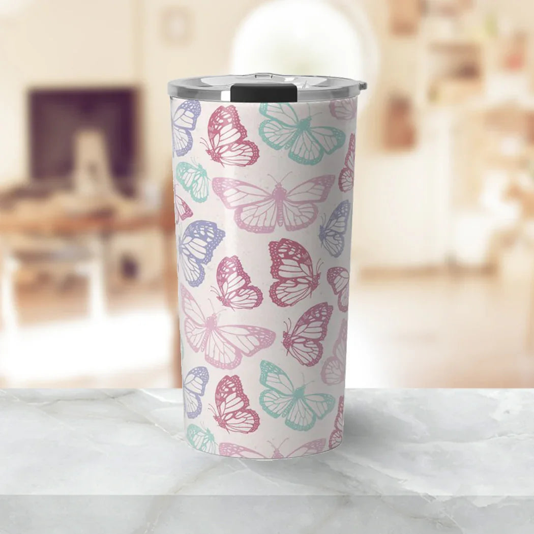 Tumbler with colorful butterfly pattern in pink, purple, and teal on a marble surface