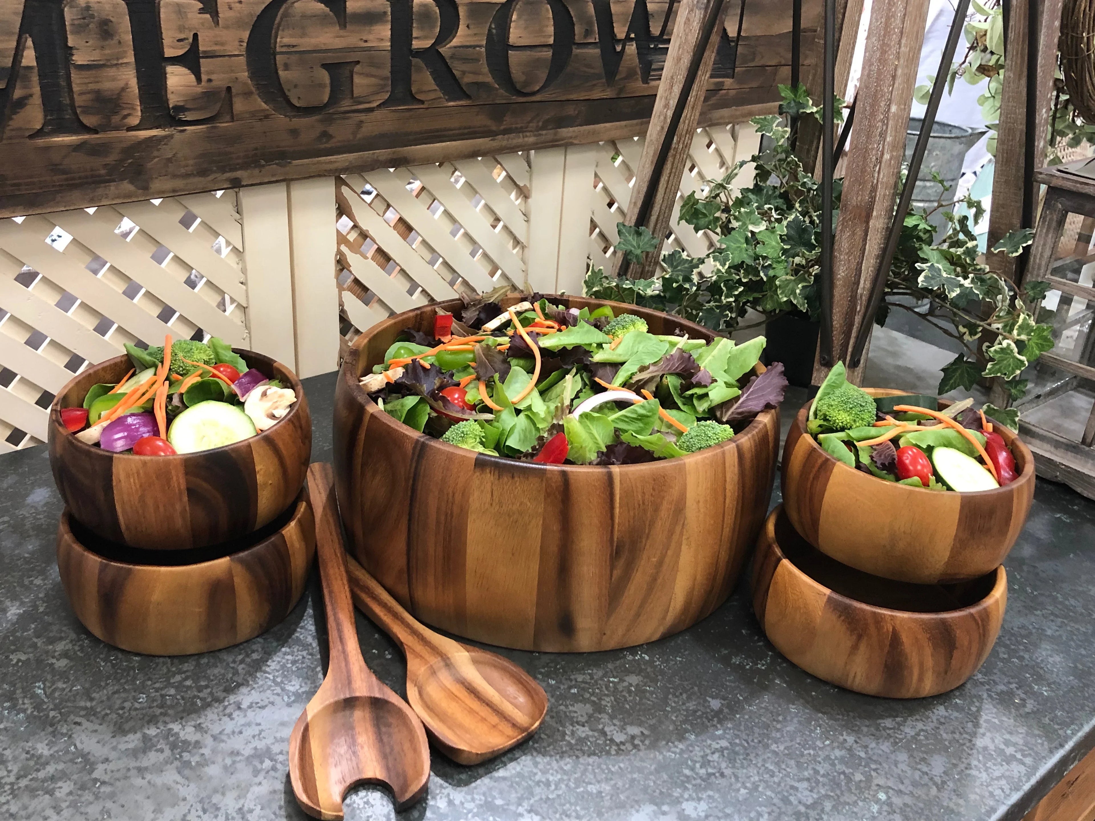 Wooden salad bowl set with fresh garden salad, displayed on a rustic table at Qu!rk Boutique.