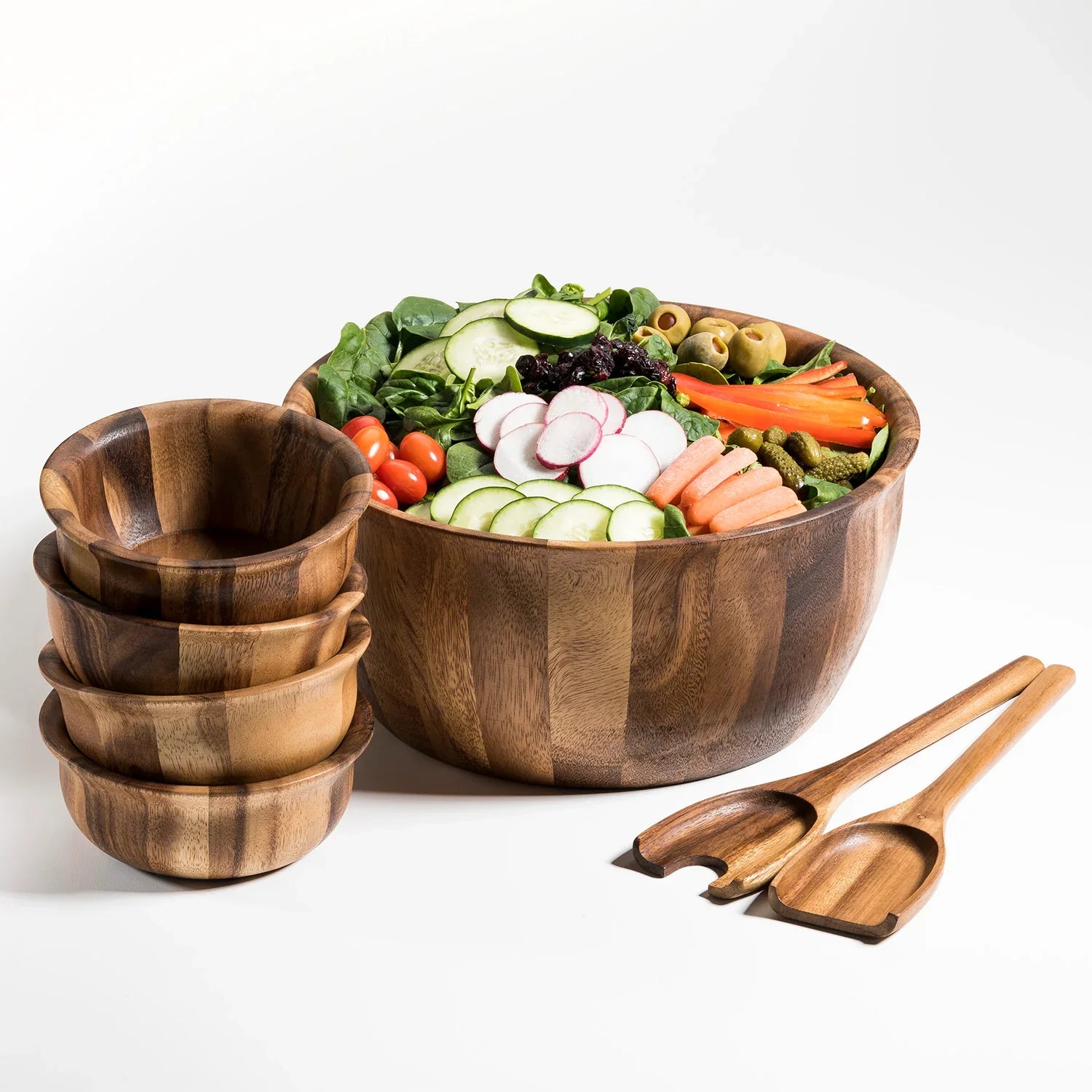 Wooden salad bowl set with servers and fresh vegetables, perfect for eco-friendly gifting.
