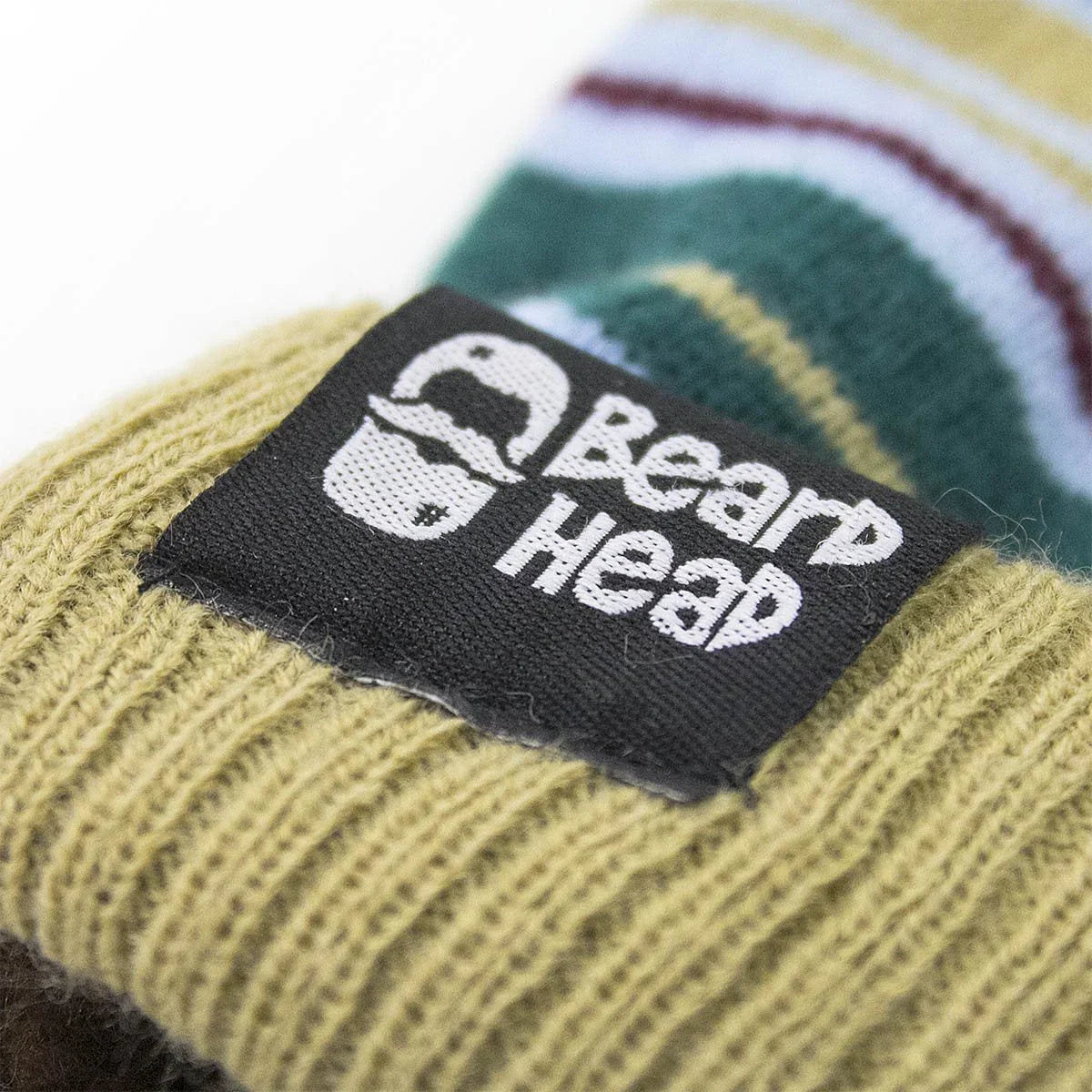 Close-up of knitted mustard yellow fabric with Beard Heap black label and logo