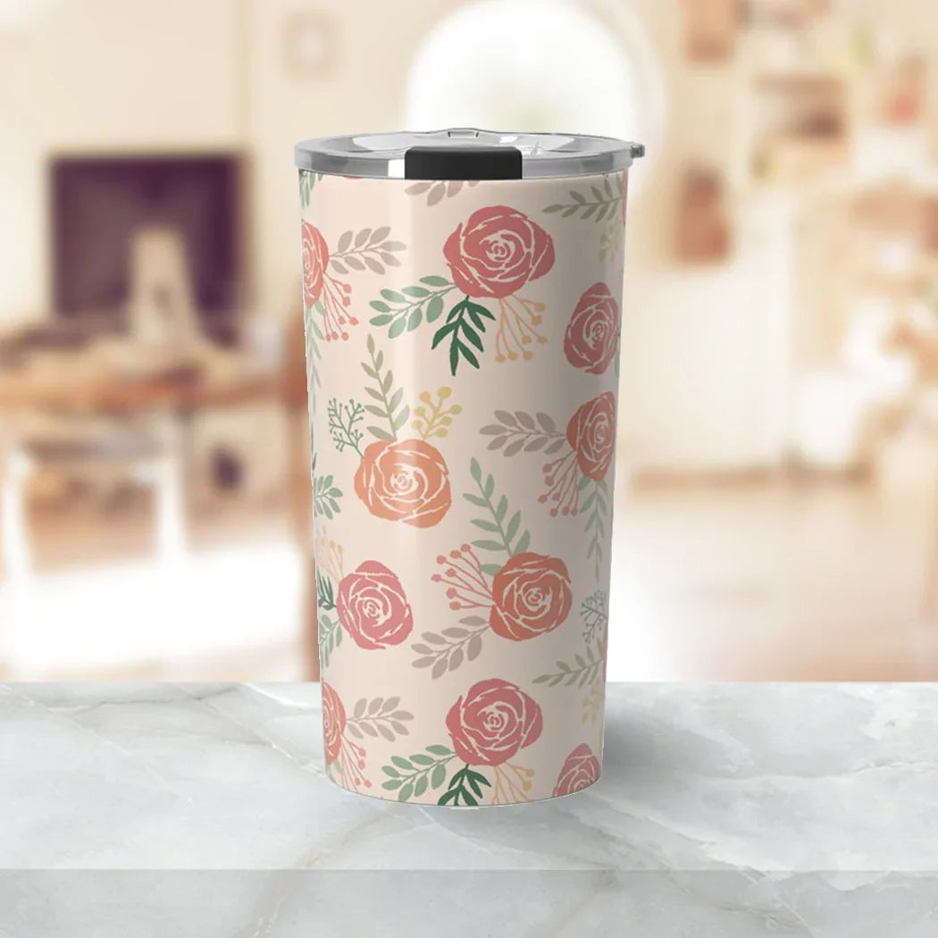 Floral patterned insulated travel tumbler with clear lid on marble surface in cozy room