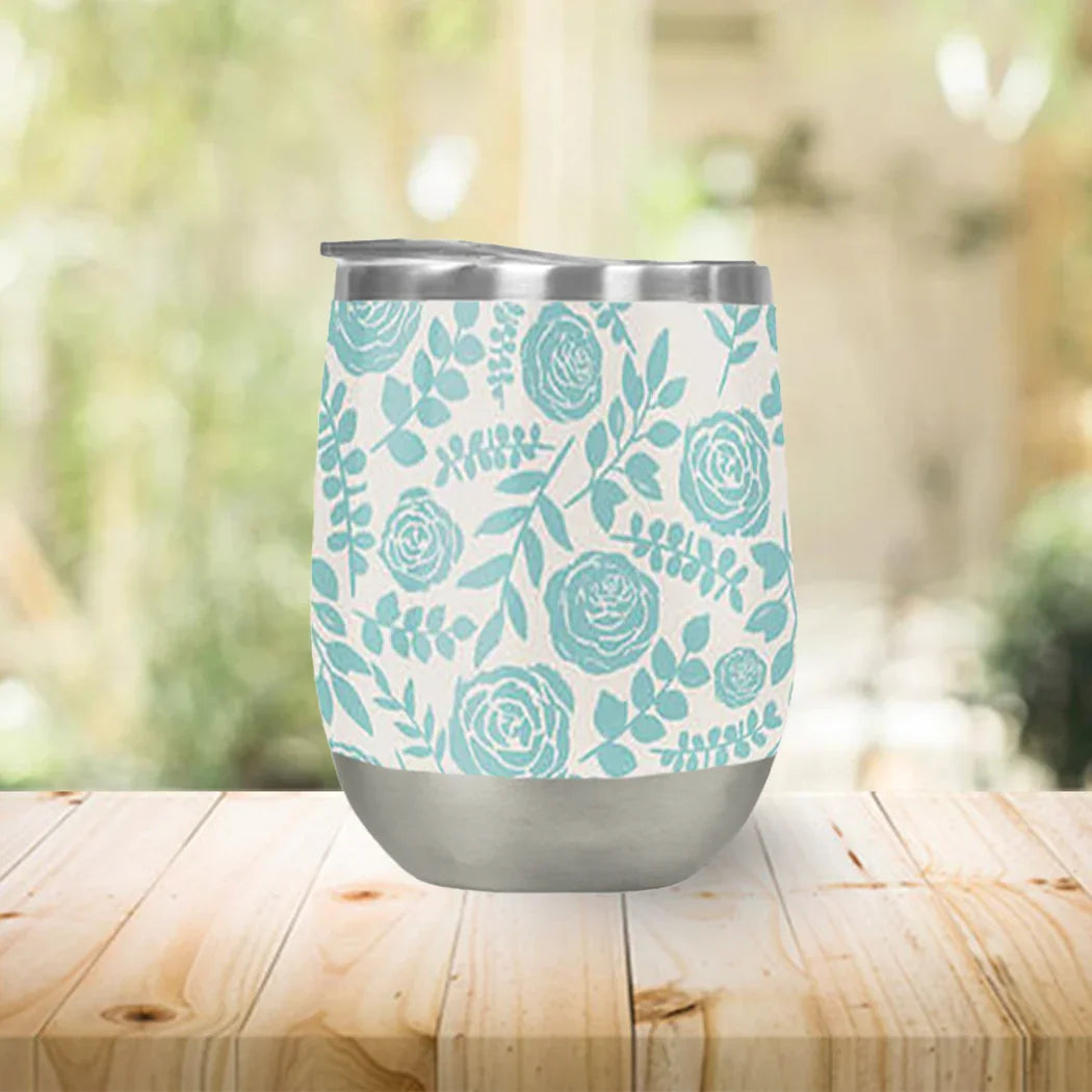 Floral stainless steel tumbler with teal rose pattern on a wooden table at Qu!rk Boutique