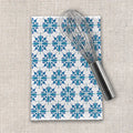 Blue floral patterned tea towel with metal whisk on textured fabric, Qu!rk Boutique kitchen gift.