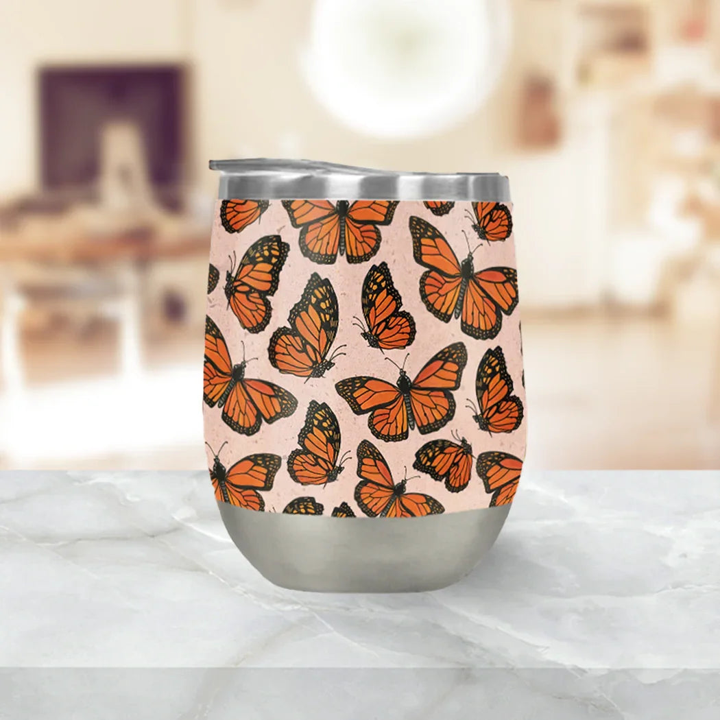 Stainless steel tumbler with orange monarch butterflies, on marble counter, Qu!rk Boutique gift