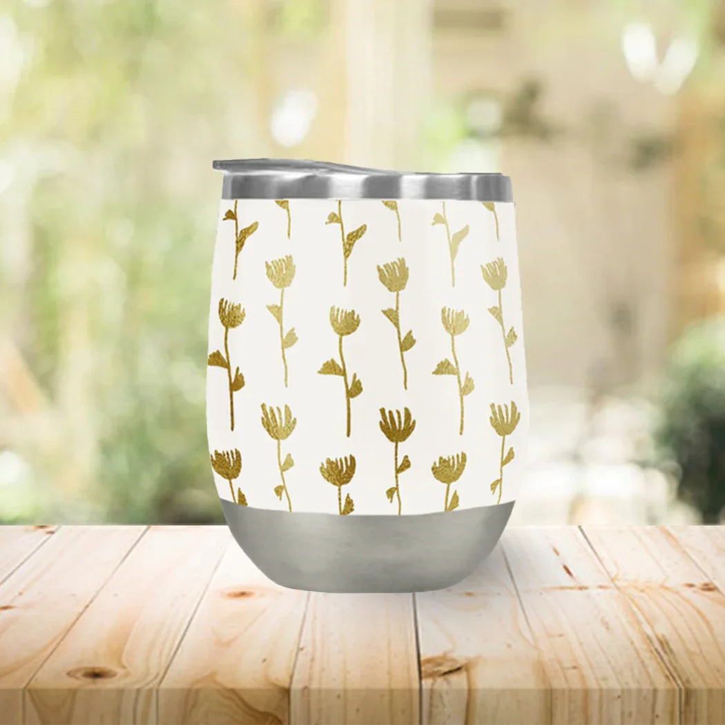 Gold floral-pattern tumbler cup on wooden table, Qu!rk Boutique eco-friendly artist gift