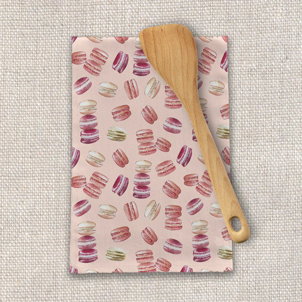 Macaron-patterned tea towel with wooden spatula on textured cloth, Qu!rk Boutique kitchen gift