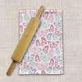 Pastel butterfly tea towel and wooden rolling pin on textured fabric, Qu!rk Boutique kitchen gift