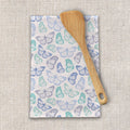 Butterfly pattern tea towel with wooden spatula on textured fabric, Qu!rk Boutique gift