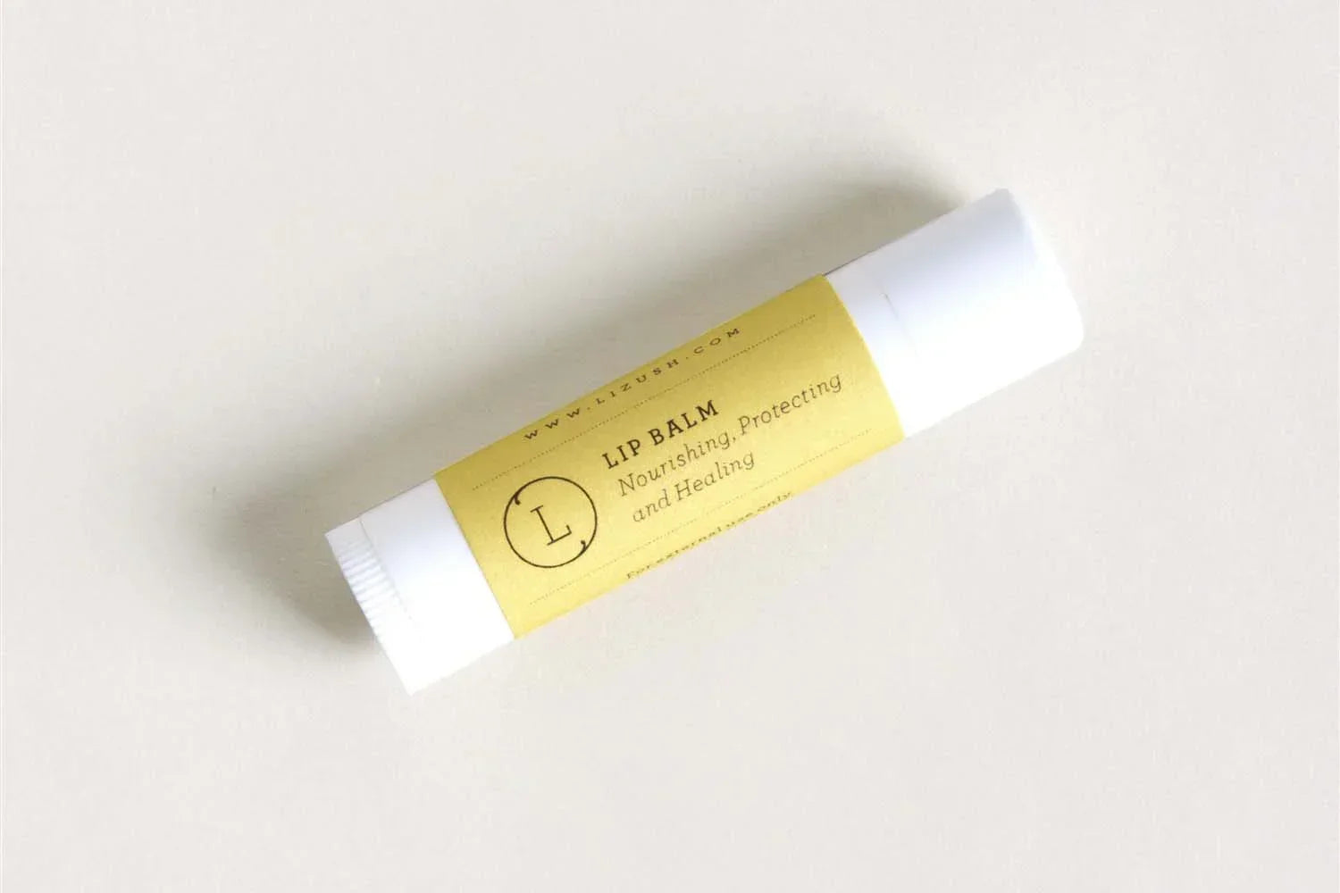 Lizush natural lip balm stick with yellow label on white background, nourishing and protecting lips