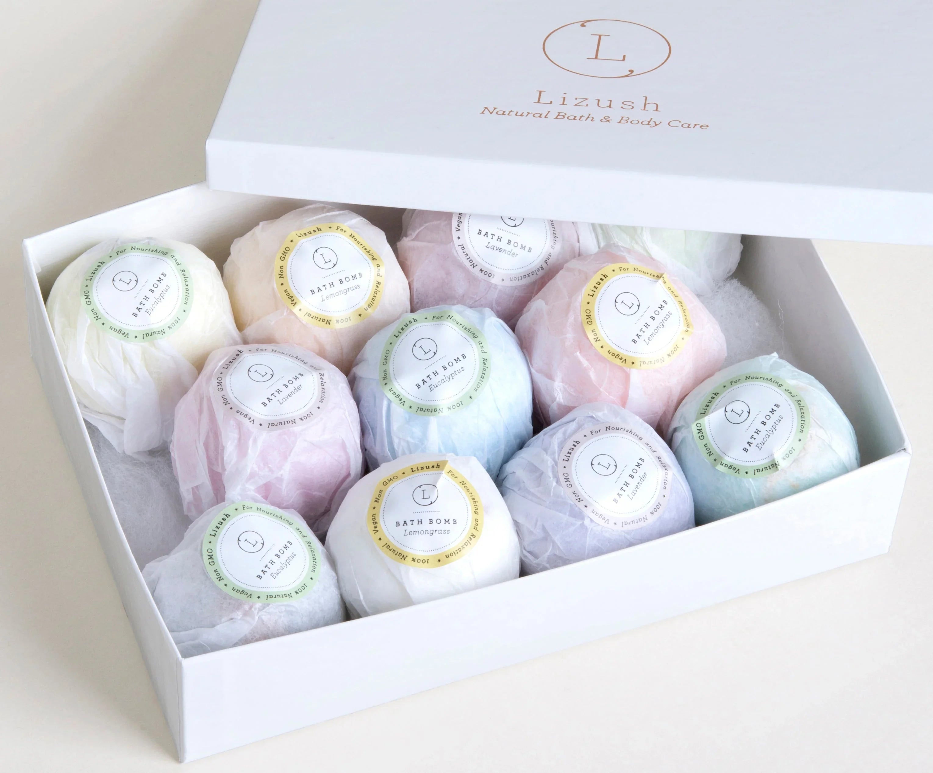 Box of 12 colorful Lizush natural bath bombs in various scents including eucalyptus, lemongrass, and lavender